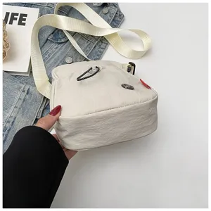 Detailopname van een minimalistische gebroken witte nylon crossbody tas voor mobiele telefoons