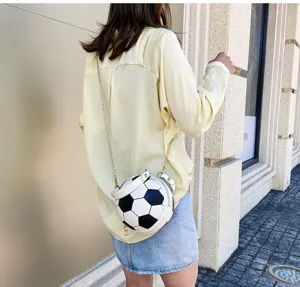Detalle de un bolso bandolera creativo con forma de balón de fútbol y cadena dorada