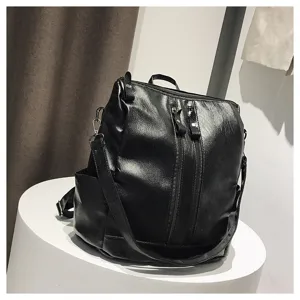 Makroansicht der weichen Ledertextur und Reißverschlussdetails des schwarzen vielseitigen Rucksacks