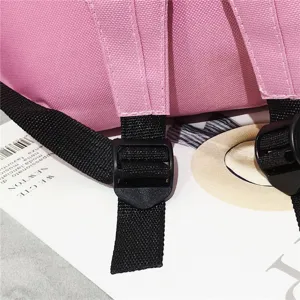 Detailansicht der verstellbaren Kunststoffschnalle an einem rosa Segeltuch-Rucksackgurt