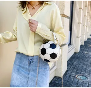 Detalle de un bolso bandolera con forma de balón de fútbol y cadena dorada elegante