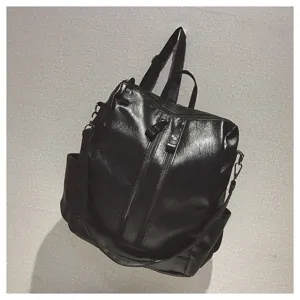 Detail eines schwarzen, multifunktionalen Rucksacks aus weichem Leder mit Zippern.