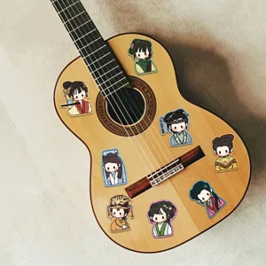 Detailansicht von Chibi-Cartoon-Aufklebern auf einer akustischen Gitarrenoberfläche.