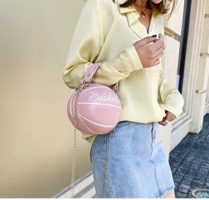 Modelo elegante con un bolso bandolera rosa en forma de baloncesto al aire libre con estilo