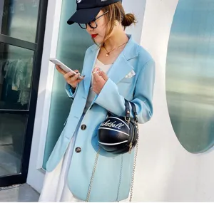 Elegante bolso bandolera con forma de baloncesto en una foto de estilo callejero.
