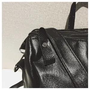 Detailaufnahme eines schwarzen Rucksacks aus weichem Leder mit strukturierter Oberfläche.
