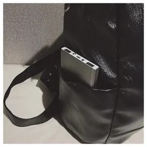 Detailansicht der Seitentasche eines schwarzen weichen Lederrucksacks mit Powerbank