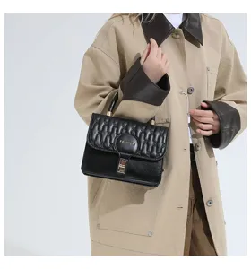 Detalle de un elegante bolso de mano acolchado negro llevado por una modelo en un estudio pro.