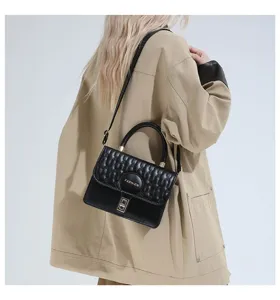 Elegante bolso bandolera bordado negro combinado con una chaqueta caqui de moda para mujer