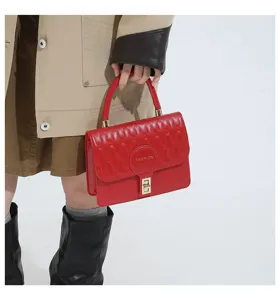Primer plano de bolso rojo acolchado con cierre dorado y parche con texto Fashion