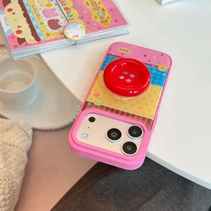 Détail de la coque iPhone rose avec pois colorés et support en forme de bouton rouge