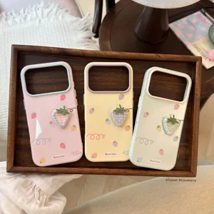 Gros plan sur les broderies de fraises en tissu sur des coques iPhone souples colorées