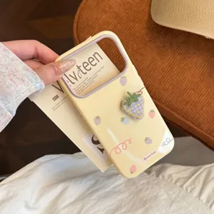 Détail d'une coque iPhone crème avec une fraise brodée en 3D et des motifs pastel doux