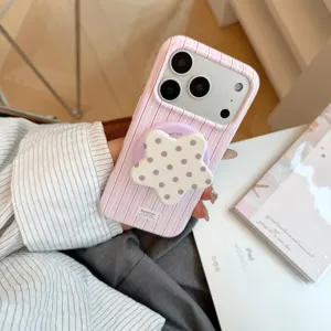 Κοντινό πλάνο ροζ ριγέ θήκης iPhone με μαγνητική λαβή σε σχήμα μωβ αστεριού για κράτημα