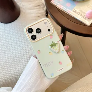Détail de la coque iPhone vert menthe avec une fraise en tissu 3D et des jolis motifs