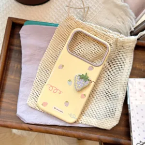Vue détaillée d'une coque de téléphone jaune souple avec broderie fraise 3D en tissu