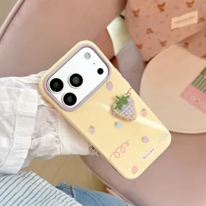 Gros plan sur le détail de la fraise brodée en 3D sur une coque iPhone jaune pastel