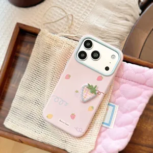 Détail d'une coque iPhone rose avec une fraise brodée en 3D et des motifs de fleurs.