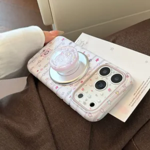 Primer plano de una funda rosa con estrellas para iPhone y soporte magnético de mármol