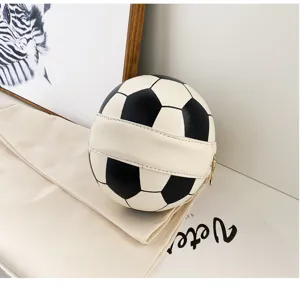 Vista detallada del bolso de mano en blanco y negro con forma de fútbol sobre blanco