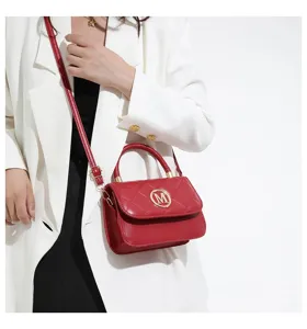 Nahaufnahme einer eleganten roten Stepphandtasche mit Goldelementen