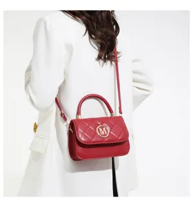 Rote gesteppte kleine Handtasche aus Leder mit goldenem M-Logo von Model getragen