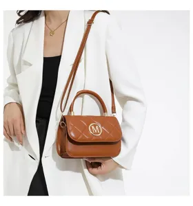 Nahaufnahme eines Models mit einer braunen gesteppten Handtasche mit goldenem M-Logo