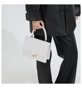 Bolso bandolera acolchado blanco con cierre dorado llevado por modelo de negro