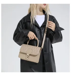 Elegante bolso bandolera acolchado beige con asa sobre un abrigo de cuero negro