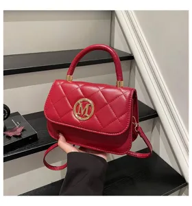 Nahaufnahme einer roten gesteppten Handtasche mit goldenem runden M-Logo-Emblem