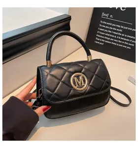 Detailansicht einer eleganten schwarzen gesteppten Handtasche mit goldenem M-Logo