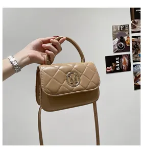 Detailansicht einer modischen gesteppten Handtasche mit goldener M-Logoschnalle.