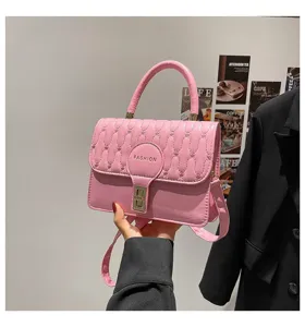Detalle de un elegante bolso bandolera acolchado rosa con logotipo de moda