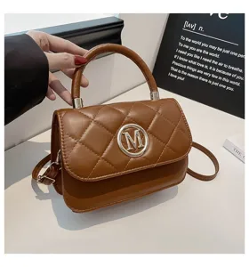 Detailansicht der braunen gesteppten Handtasche mit runder Metallschnalle am Deckel