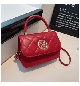 Nahaufnahme der roten gesteppten Handtasche mit goldenem M-Logo
