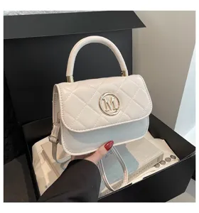 Detailansicht der weißen gesteppten Handtasche mit elegantem goldenem M-Logo.