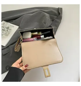 Detalle interior de un bolso de hombro beige con espacio para artículos diarios