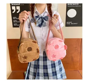 Une mannequin tenant deux adorables sacs à bandoulière en peluche capybara rose et brun