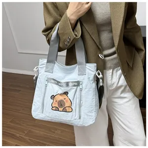 Large capacity light blue tote bag with cute cartoon capybara print shown on model