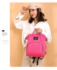 Mochila pañalera rosa multifuncional para mamás, llevada por una modelo mujer.