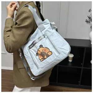 Cute capybara print light blue shoulder bag for women, showing model wearing style.