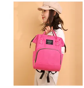 Modelo femenina asiática sosteniendo una elegante mochila pañalera rosa multifuncional