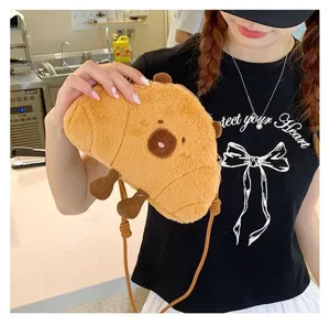 Close-up detail of a cute cartoon Capybara plush crossbody bag worn by a model