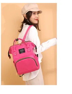 Mochila pañalera rosa elegante de gran capacidad para mamás, lucida por modelo.