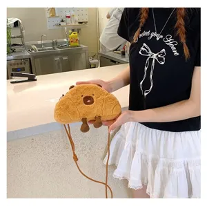 Close-up of a cute plush Capybara crossbody bag held by a model in a cafe setting