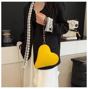 Detalle de un monedero de cuero amarillo en forma de corazón con correa LOVE.