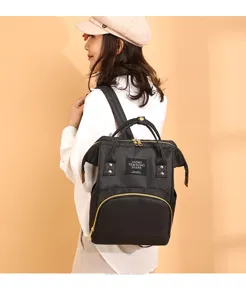 Modelo asiática de moda con una mochila para pañales negra de gran capacidad