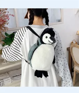Detailansicht eines süßen Pinguin-Plüschrucksacks, getragen von einem Mädchen
