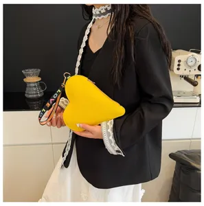 Detalle de estilo de un bolso de mano amarillo en forma de corazón con asa de LOVE