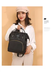 Primer plano de la mochila pañalera multifuncional negra llevada por una modelo.